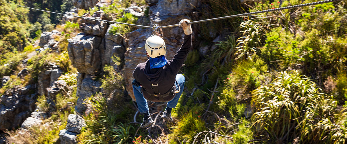 Man ziplining through a valley