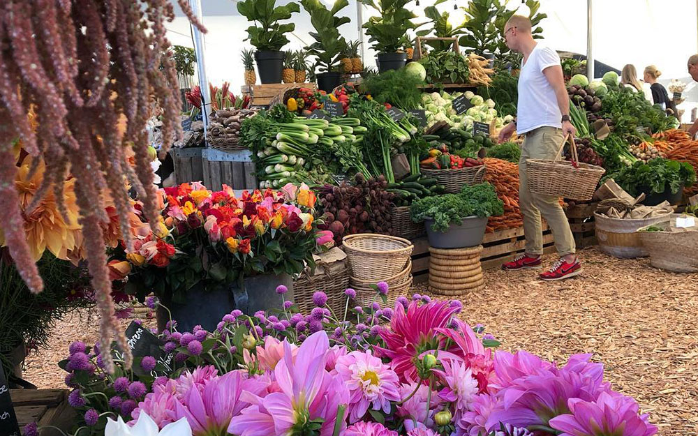 man looking at flowers and fresh produce at Cape Town Oranjezicht market