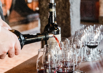 Vintage port being poured into glasses in port wine cellar